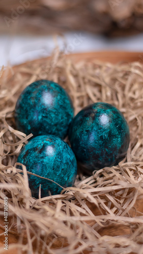 Dyed eggs in dark tidewater green tones. Easter festive background, open card, eggs close-up. Table setting for the Easter holiday. Christ is Risen Easter holiday.