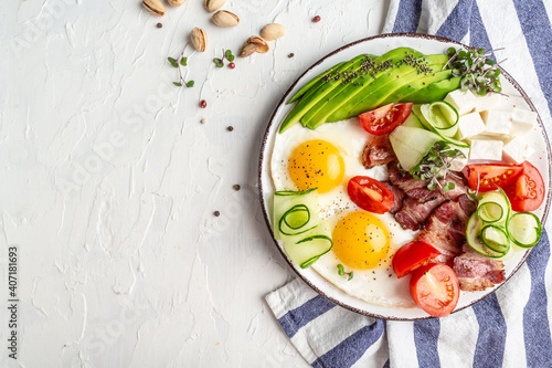 healthy keto breakfast egg, avocado, cheese, bacon and fresh salad. Healthy nutritious paleo keto breakfast concept. place for text, top view
