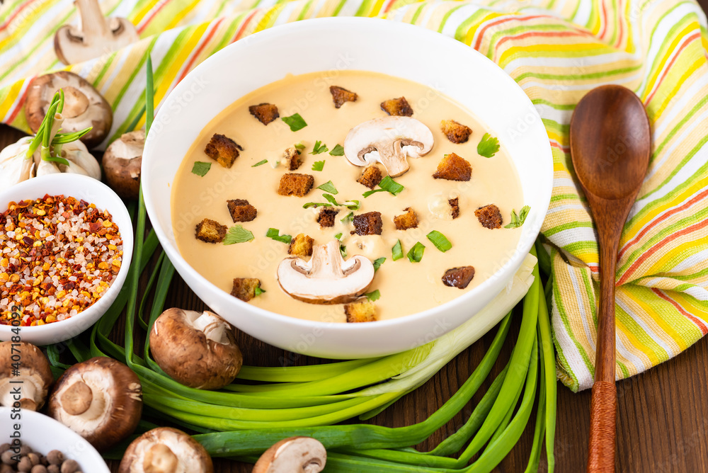 Mushroom soup with onions, garlic and pepper on a wooden table. Mushroom soup with onions, garlic and pepper on a wooden table.