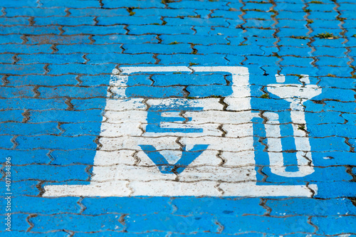 EV sign for electric vehicle power supply recharge on a blue floor outdoors in a street concept green energy in South Africa and technology
