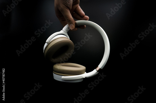 man hand holding headphones on black background. music concept photo