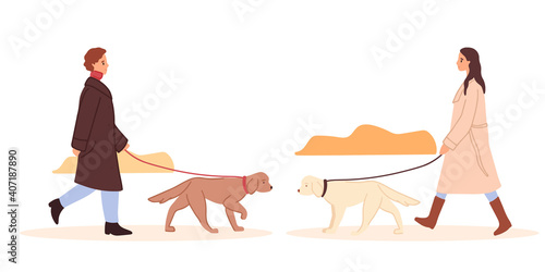Man and Woman wearing warm coat walks labrador retriever dog on leash. Pet walking service. Teenage girl spend time at autumn park, doggy walk outdoors. Care of animals. Dog meeting, animal friendship