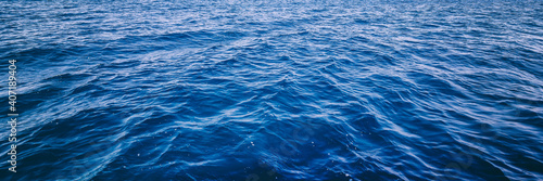 Blue deep sea ocean water in calm, banner format © olezzo
