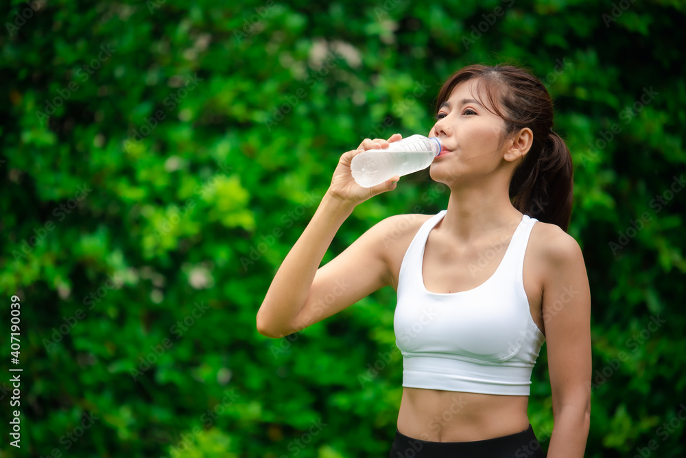 Asian young woman drinking water after workout exercising. Asian young woman drinking water after workout exercising.