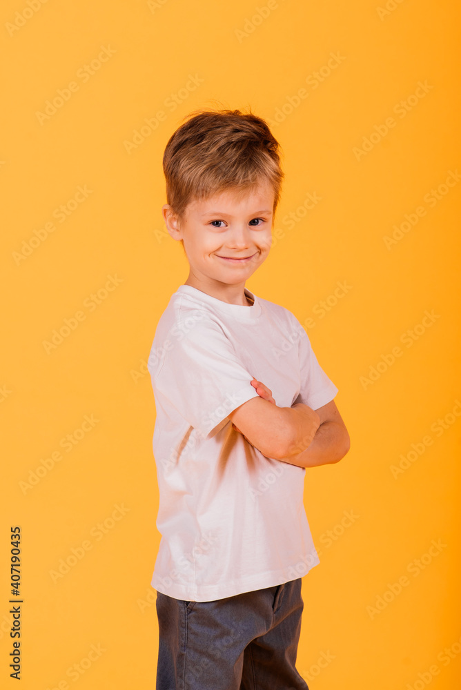 Portrait of happy little boy over yellow background