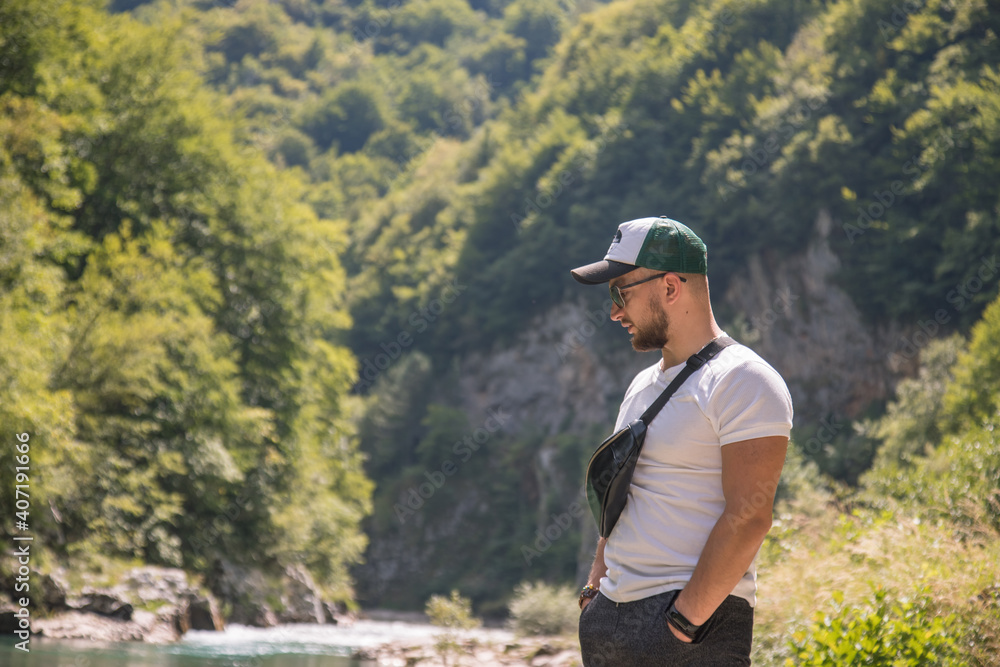 Portrait of handsome stylish man on walk near riverside. Canyon Tara , Montenegro.