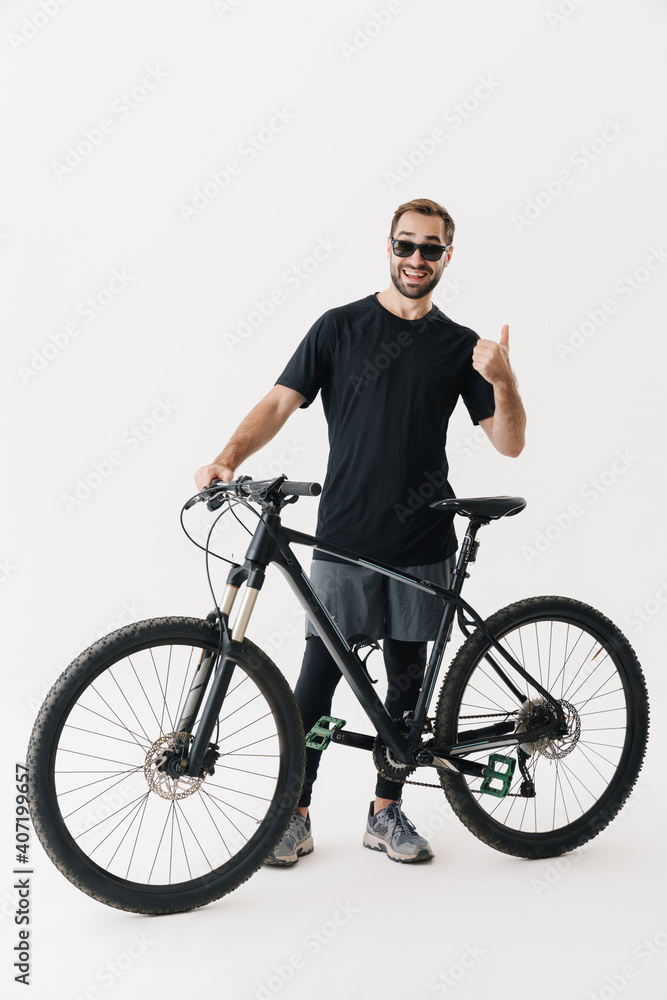 Happy rider man showing thumb up while posing with his bicycle Happy rider man showing thumb up while posing with his bicycle