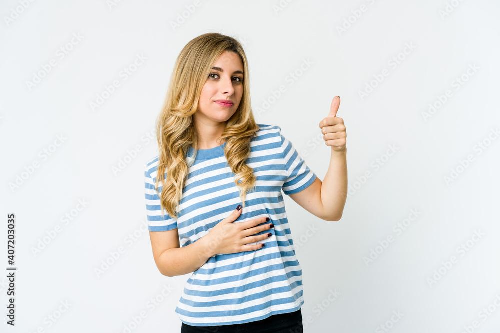 Young caucasian blonde woman touches tummy, smiles gently, eating and satisfaction concept. Young caucasian blonde woman touches tummy, smiles gently, eating and satisfaction concept.