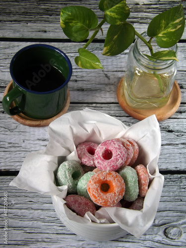 Image of Indonesian traditional snack called tai kucing or bidaran / widaran manis in colorful ring shape. Made from eggs, tapioca flour, sugar, and salt. Surface is layered by granulate sugar. photo