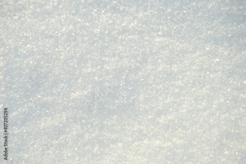 The texture of the white shining snow. Snow cover. Space for copying. The background.