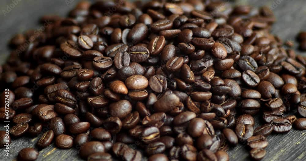 Roasted arabica coffee beans scattered on a wooden table. Fresh coffee beans. Espresso, americano, doppio, cappuccino, latte. Robusta. Selective focus. Roasted arabica coffee beans scattered on a wooden table. Fresh coffee beans. Espresso, americano, doppio, cappuccino, latte. Robusta. Selective focus.