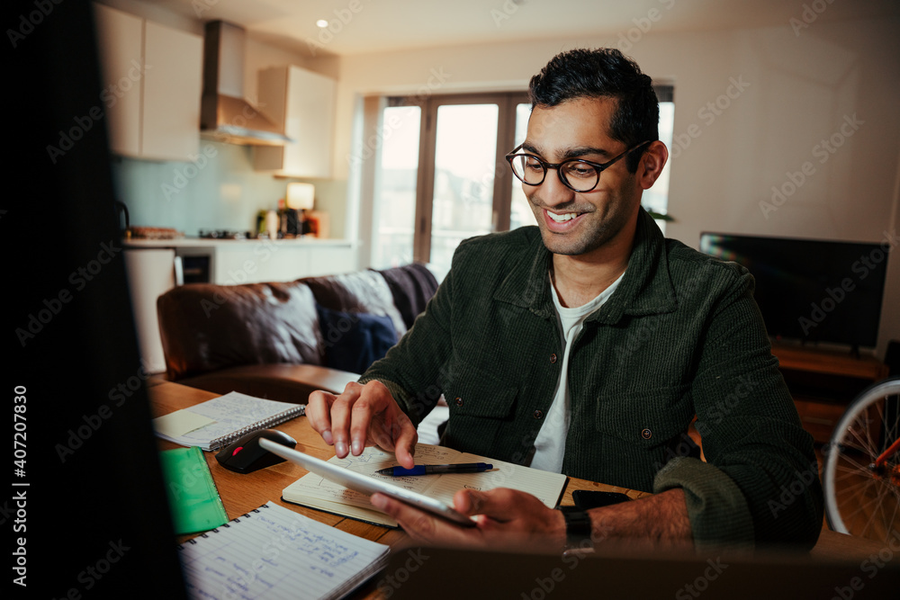 Mixed race smiling businessman interacting on video call with clients working from home office Mixed race smiling businessman interacting on video call with clients working from home office