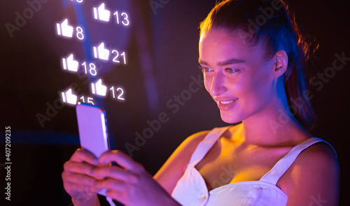 Foto Excited Lady Using Smartphone With Like Buttons Networking Standing Indoors