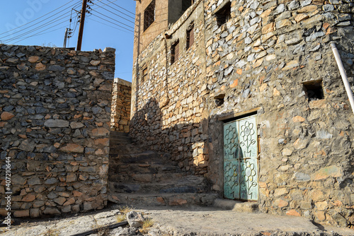 A staircase and ancient buildings made of stone in the abandoned village of Misfat Al Abriyeen  Oman  in a sunny day.