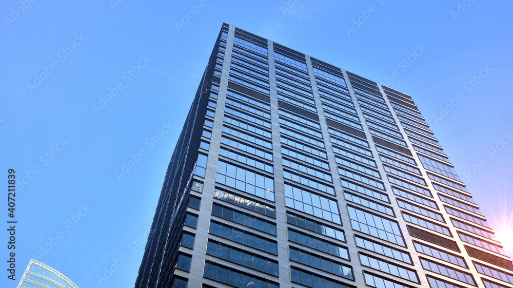 Concept for real estate and corporate construction..The modern office building of the orange morning sun in the sky background. Concept for real estate and corporate construction..The modern office building of the orange morning sun in the sky background.