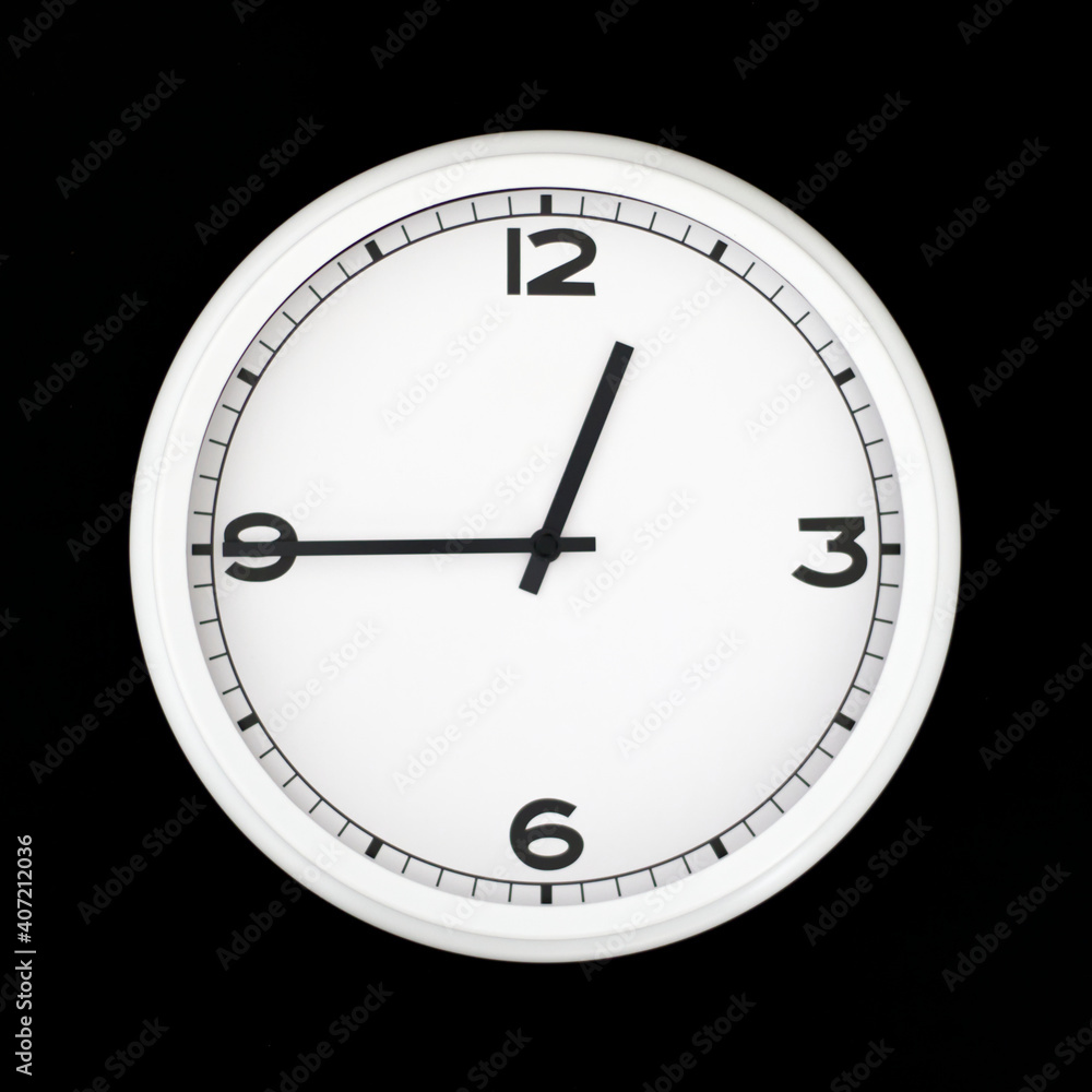 White round analog wall clock isolated on black background. White round analog wall clock isolated on black background.