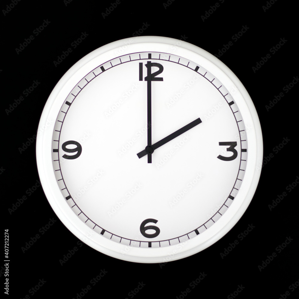 White round analog wall clock isolated on black background. White round analog wall clock isolated on black background.
