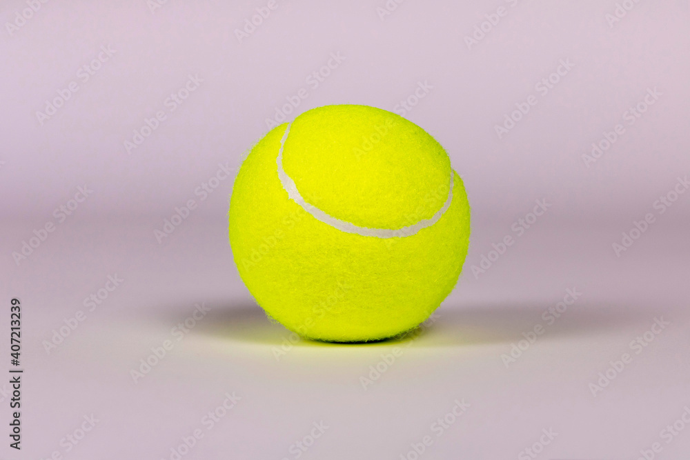 Yellow tennis ball on a light background. Close-up.