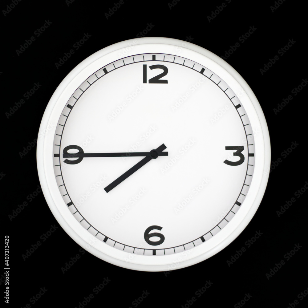 White round analog wall clock isolated on black background.