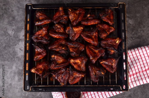 Grilled chicken wings on a baking sheet. Roasted in oven crispy sticky honey chicken wings, top view