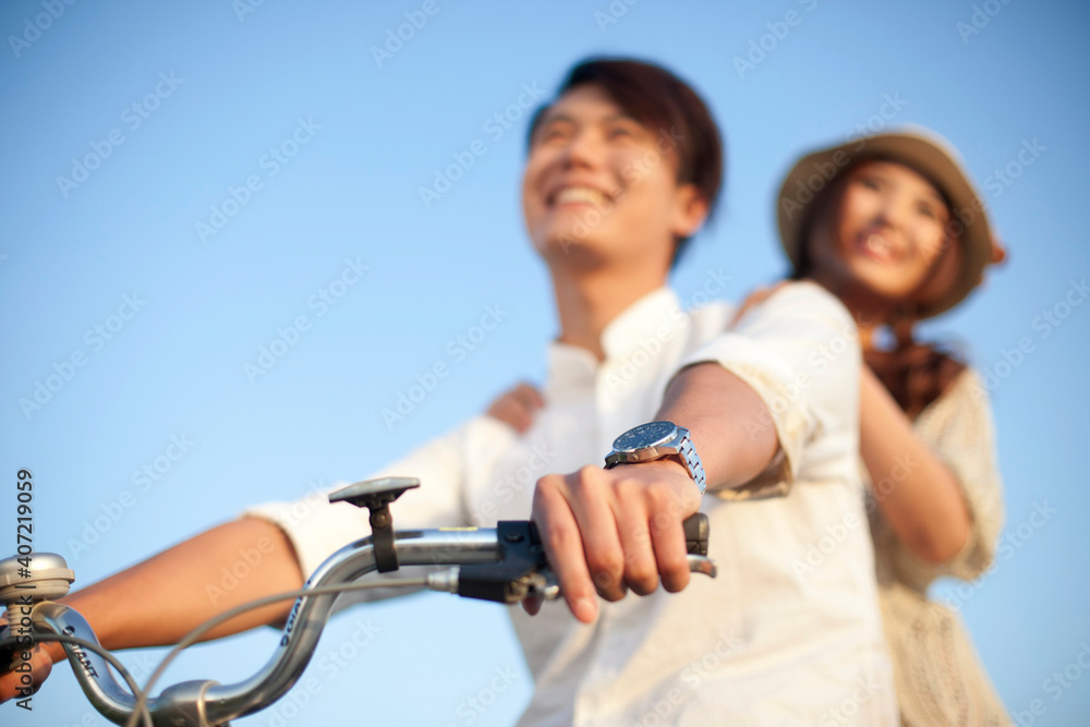 Obraz premium The young couple riding a bicycle