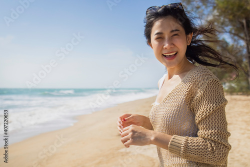 Summer vacation serenity concept, Asian beautiful young female in casual outfit smiling relaxing on beach photo