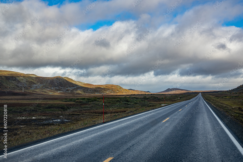 Straight road through a sparse landscape in Norway Straight road through a sparse landscape in Norway