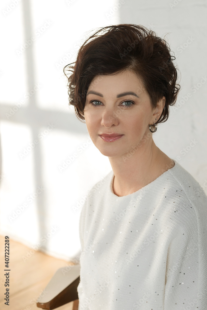 An active, beautiful, middle-aged woman. Close-up of a woman's face with a smile. Mature healthy woman for advertising in the studio on a white background An active, beautiful, middle-aged woman. Close-up of a woman's face with a smile. Mature healthy woman for advertising in the studio on a white background