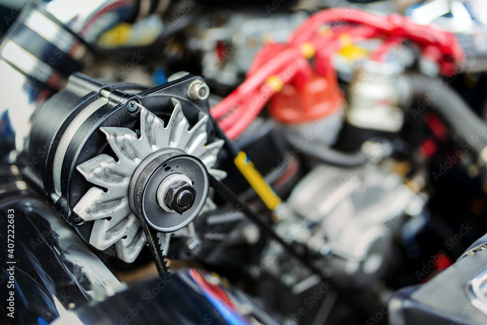 View of an alternator in the engine of an old race car. Alternator is a