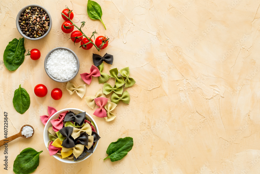 Coloured vegan pasta with tomatoes and fresh basil, view fron above Coloured vegan pasta with tomatoes and fresh basil, view fron above
