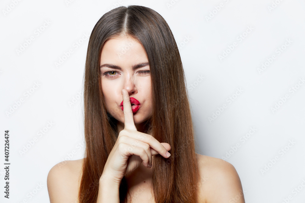 Woman Secret finger near lips portrait clear skin isolated background Woman Secret finger near lips portrait clear skin isolated background
