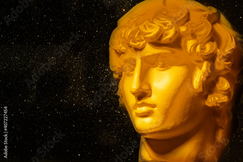 A statue. Plaster decorative golden statue of the head of Apollo.