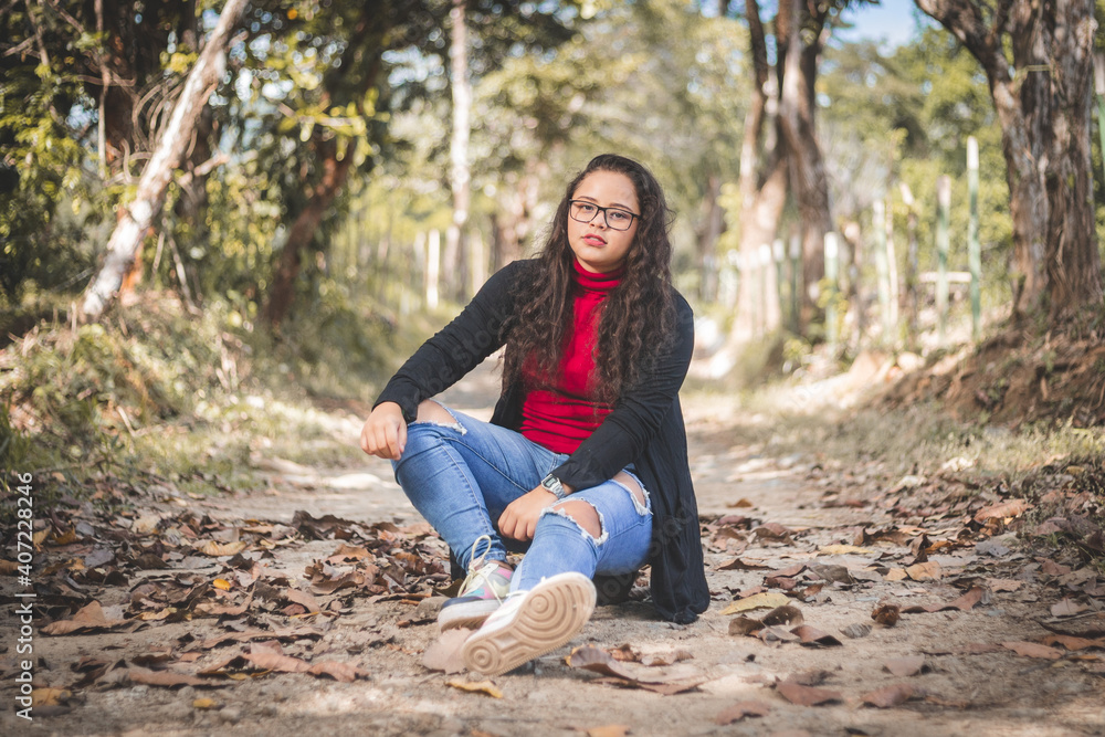 Mujer sentada en la tierra con perro labrador color crema. Labrador con lazo rojo. Mujer con Lentes y Camisa negra con roja. Mujer sentada en la tierra con perro labrador color crema. Labrador con lazo rojo. Mujer con Lentes y Camisa negra con roja.