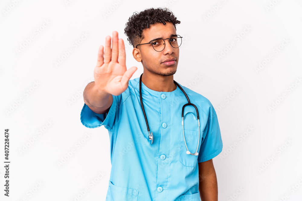 Young african american curly nurse man isolated standing with outstretched hand showing stop sign, preventing you. Young african american curly nurse man isolated standing with outstretched hand showing stop sign, preventing you.