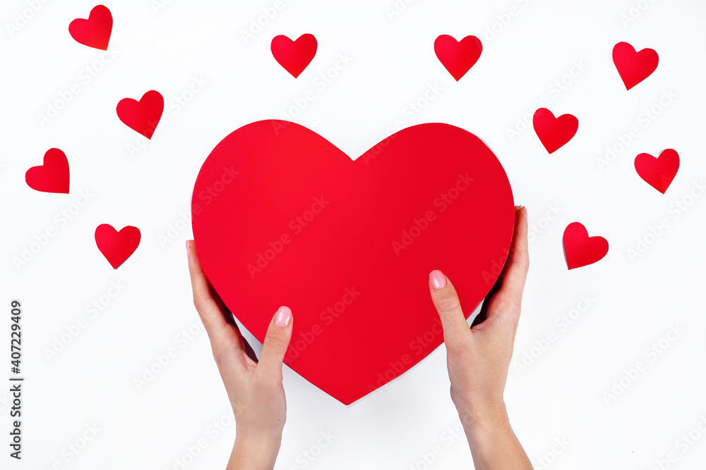 Close-up on female hands holding a gift in a pink heart, presents for Valentine's Day, Birthday, Mother's Day. Flat lay. Love symbol.
Close-up on female hands holding a gift in a pink heart, presents for Valentine's Day, Birthday, Mother's Day. Flat lay. Love symbol.