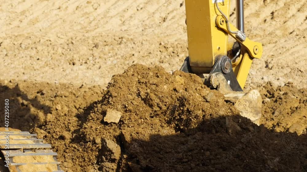 Yellow excavator digging the ground in slow motion, Close up Yellow excavator digging the ground in slow motion, Close up
