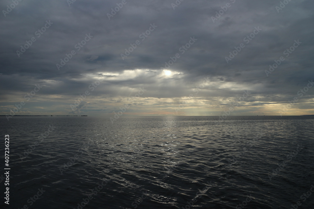 dark heavy clouds over the sea, a beam of light breaks through the dark storm clouds, seascape