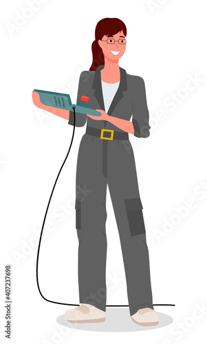 Girl mechanic dressed in a special uniform gray work overalls, holding control panel from the machine isolated on white. Modern woman in the male profession, car service worker or factory engineer