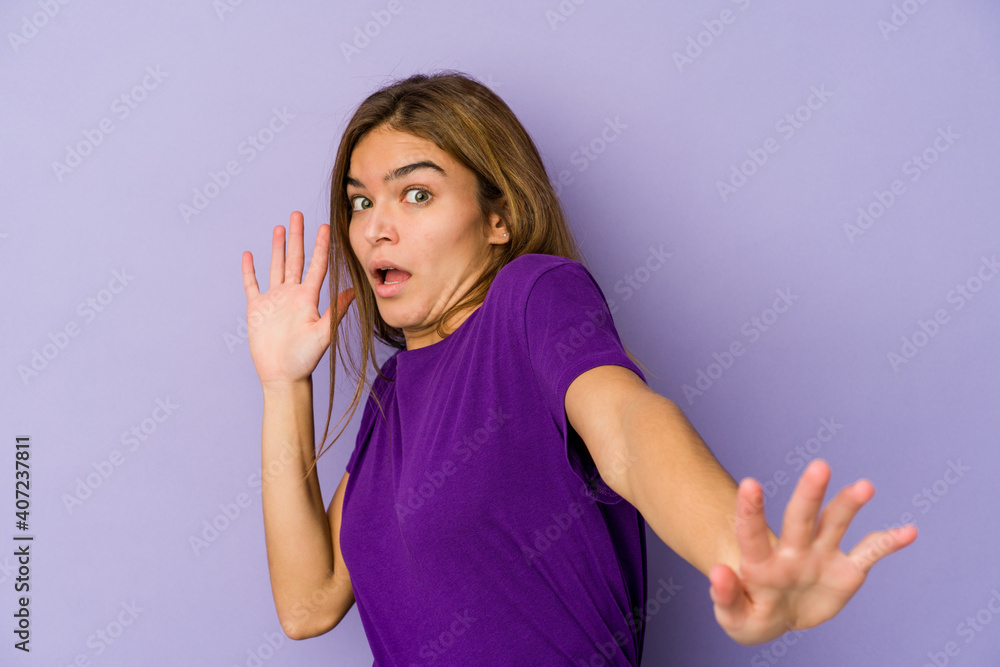 Young skinny caucasian girl teenager on purple background being shocked due to an imminent danger Young skinny caucasian girl teenager on purple background being shocked due to an imminent danger