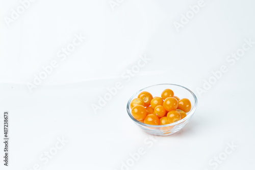 Glass container contains several cape gooseberries. Exotic tropical fruits.