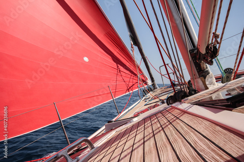 Sail boat at the sea. Sailing yacht under red sail.