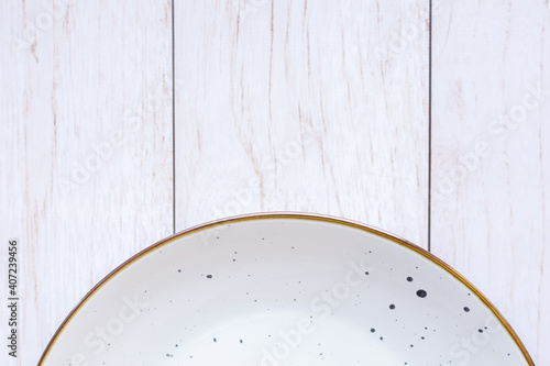 White ceramic plate on wood background, top view