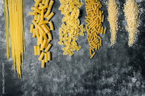Obraz na płótnie on black and white ground, auger pasta, pipe pasta, spaghetti, bow tie pasta