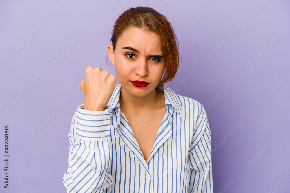 Young arab mixed race woman showing fist to camera, aggressive facial expression. Young arab mixed race woman showing fist to camera, aggressive facial expression.