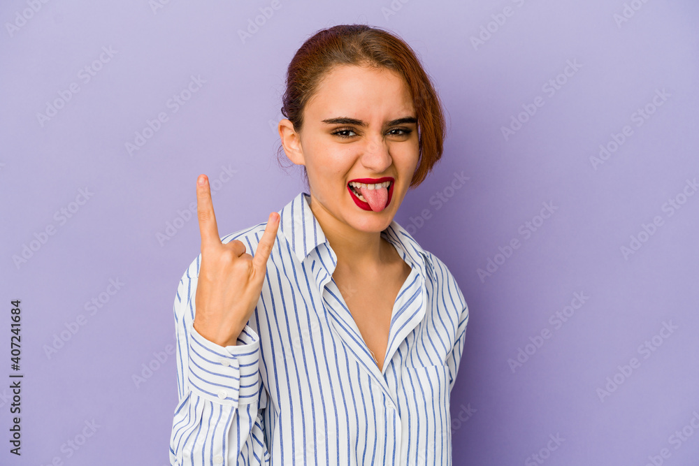 Young arab mixed race woman showing rock gesture with fingers Young arab mixed race woman showing rock gesture with fingers