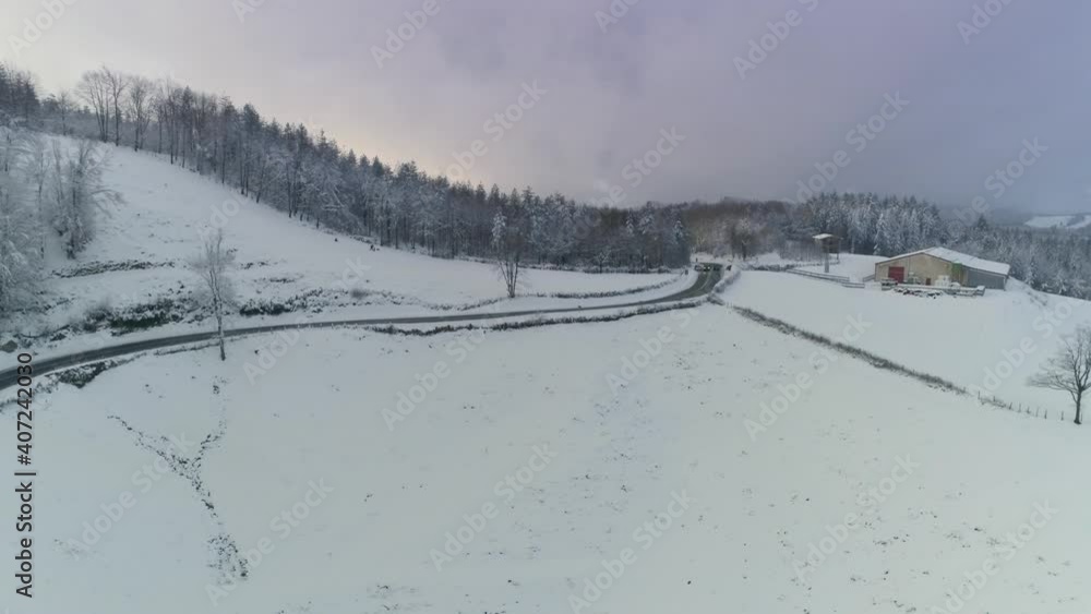 Winter aerial flyover of a country road through a snowy mountain forest in Spain rotating aerial view. Winter aerial flyover of a country road through a snowy mountain forest in Spain rotating aerial view.