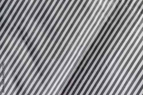 Diagonal striped fabric texture. White and gray textile background