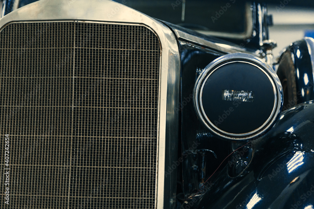 front halogen headlights and radiator of black retro car on display front halogen headlights and radiator of black retro car on display