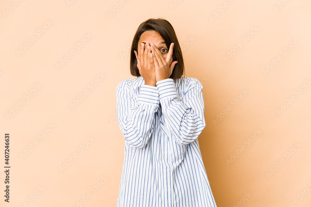 Young hispanic woman isolated blink through fingers frightened and nervous. Young hispanic woman isolated blink through fingers frightened and nervous.