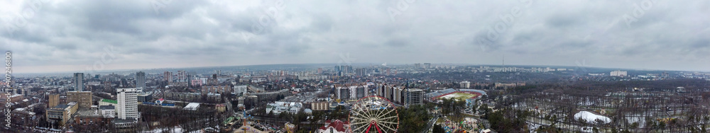 Kharkiv city center and Park of Maxim Gorky big wide panorama. Ferris wheel and high modern buildings aerial day view with gray scenic sky